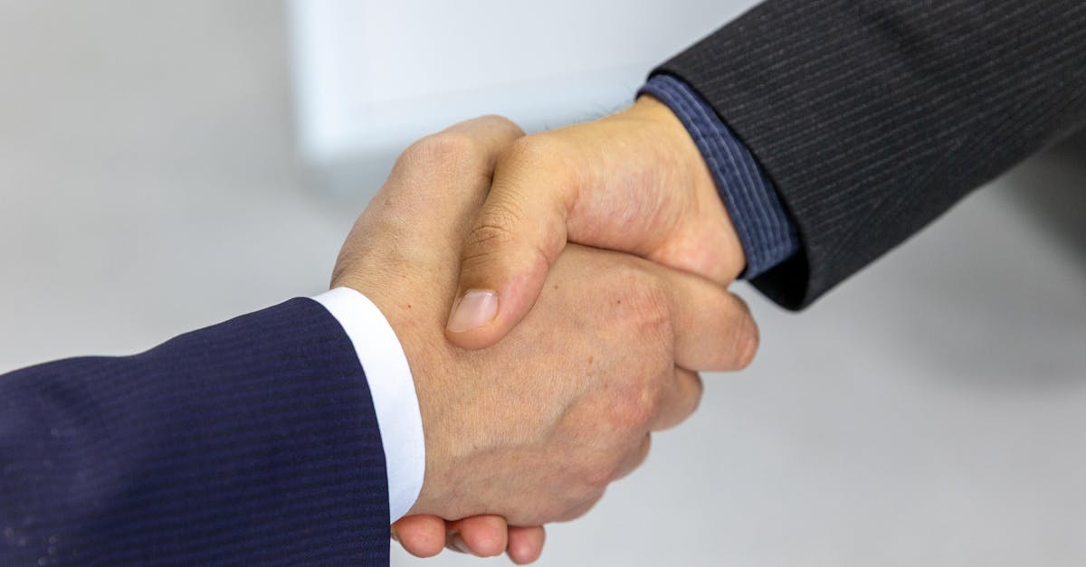 Close-up of two business executives shaking hands, symbolising a corporate acquisition agreement.