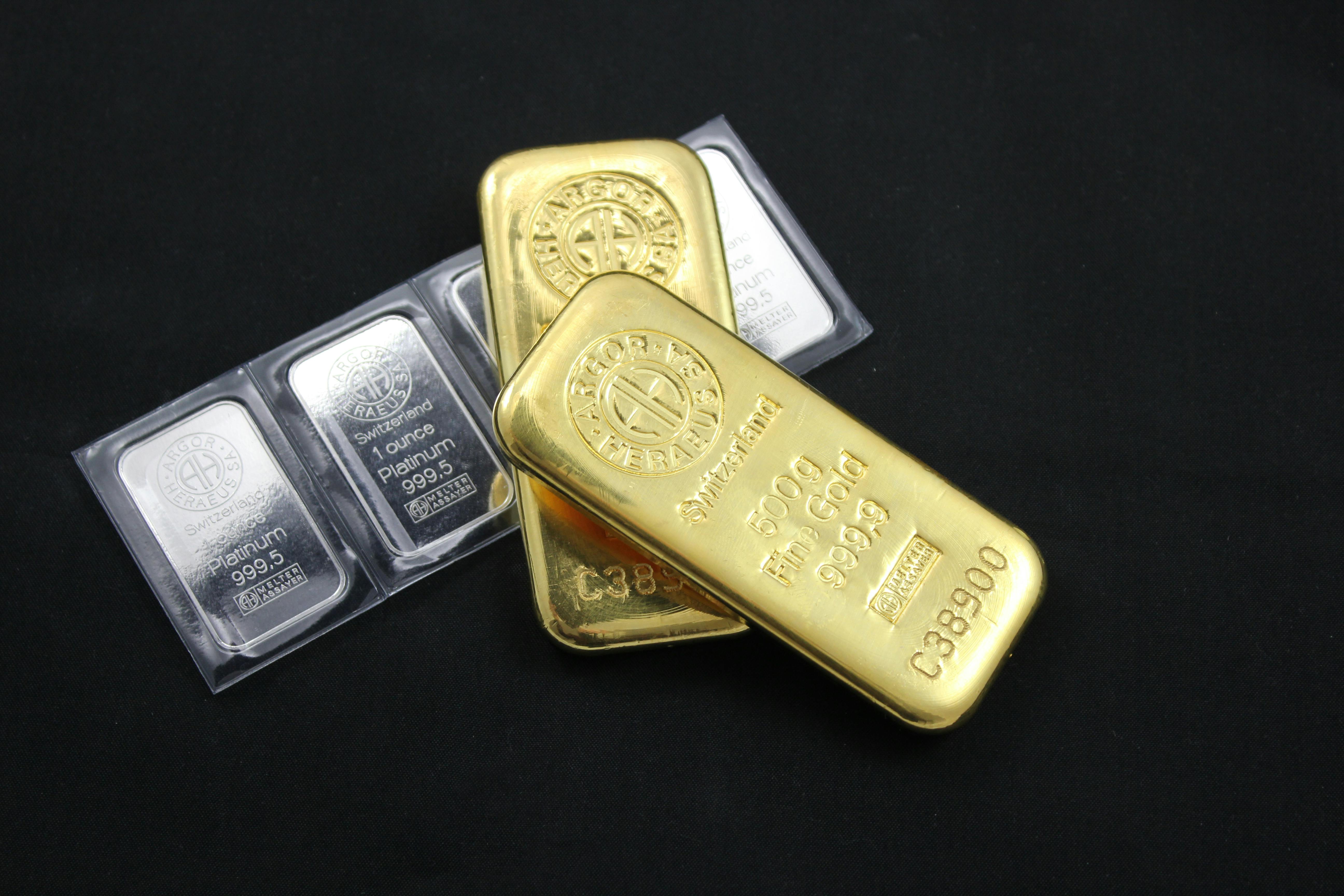 Close-up of gold bars stacked on a reflective surface representing precious metals investment