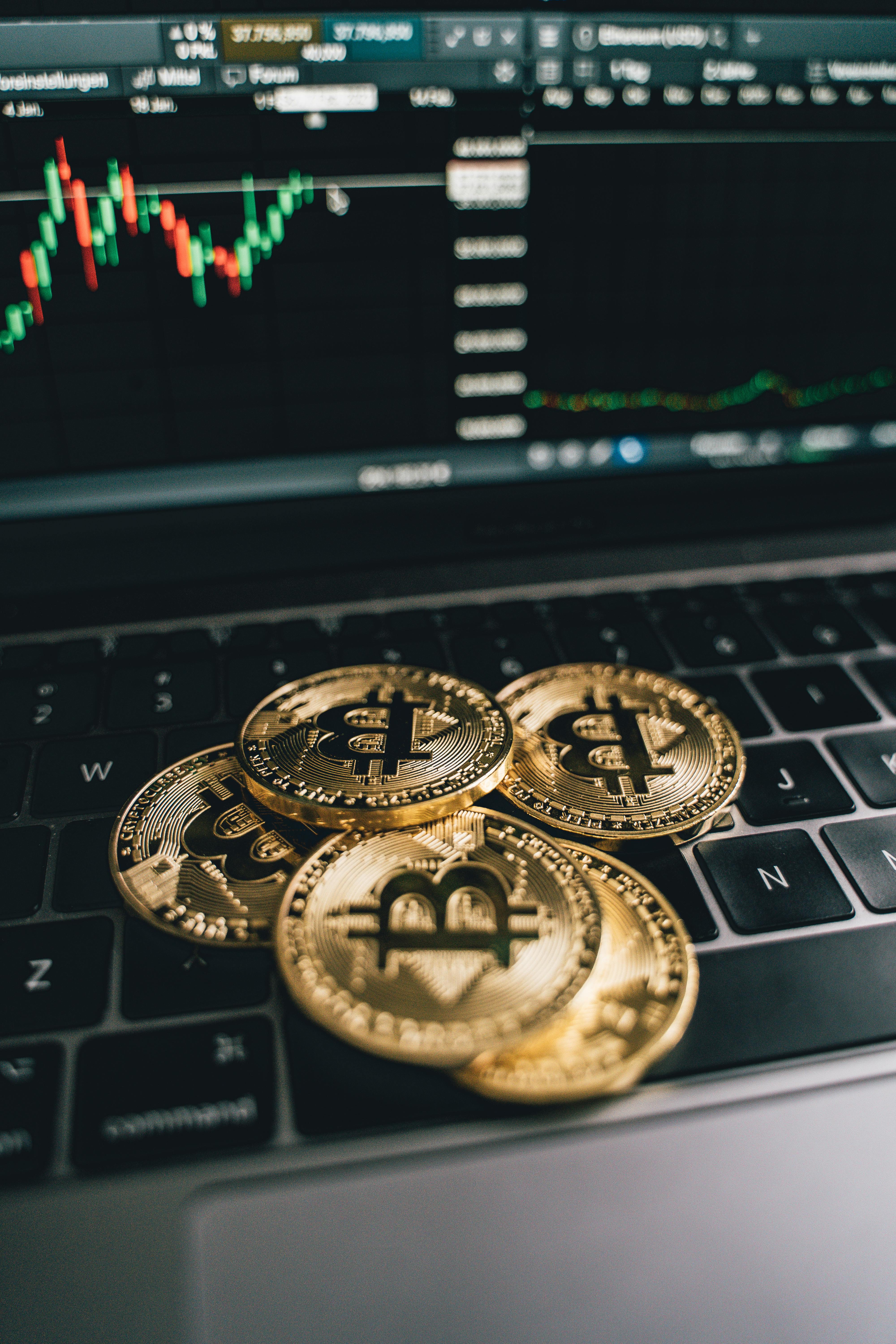 Bitcoin on a laptop screen with financial charts, cryptocurrency investment concept
